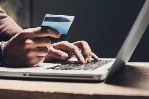 Men entering credit card information using laptop computer keyboard. Online shopping concept